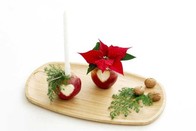 Inserire una candela in una delle mele, riempire la provetta nell'altra mela con dell'acqua e inserire una Stella di Natale recisa. Disporre tutto sul vassoio,aggiungendo altre decorazioni. Inserire una candela in una delle mele, riempire la provetta nell'altra mela con dell'acqua e inserire una Stella di Natale recisa. Disporre tutto sul vassoio,aggiungendo altre decorazioni.