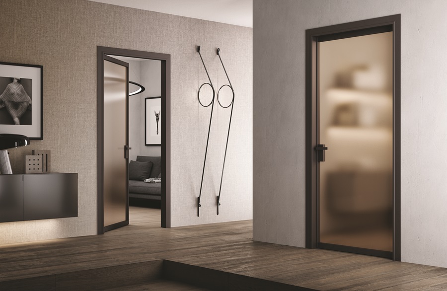 La porta a battente Simple Light di BiHome ha telaio e profili in alluminio con finitura Brown. L'anta è in cristallo Satinato Bronzo, che scherma l'ambiente senza permettere di vedere all'interno, ma lasciando filtrare la luminosità. La maniglia è il modello Basco finitura con finitura Brown. www.bihome.it La porta a battente Simple Light di BiHome ha telaio e profili in alluminio con finitura Brown. L'anta è in cristallo Satinato Bronzo, che scherma l'ambiente senza permettere di vedere all'interno, ma lasciando filtrare la luminosità. La maniglia è il modello Basco finitura con finitura Brown. www.bihome.it