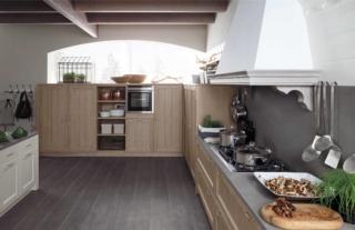 cucina ante in abete massello color nocciola Tabià di Scandola con piano in pietra: Tabià di Scandola Mobili è la cucina country di grandi dimensioni che accosta alle ante in abete massello color nocciola  il lungo piano in pietra Gaja Brown, lo stesso materiale in cui sono realizzati anche il lavello e il pannello a parete. La cappa a camino, grande e scenografica, domina l'intera composizione. Prezzo su richiesta. www.scandolamobili.it