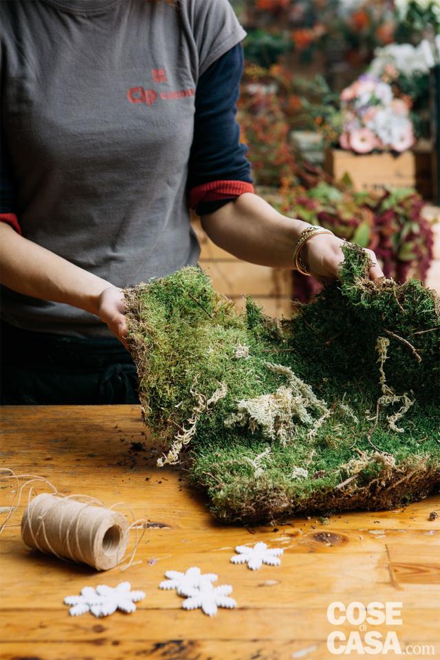 1. Dopo aver preparato tutto il necessario per la composizione fai da te sul banco da lavoro, sollevare delicatamente i fogli di muschio e pulirli da eventuali residui di foglie secche. Avvicinare il contenitore del giacinto e tagliare il muschio necessario per ricoprire i tre vasetti (parte superiore compresa). 1. Dopo aver preparato tutto il necessario per la composizione fai da te sul banco da lavoro, sollevare delicatamente i fogli di muschio e pulirli da eventuali residui di foglie secche. Avvicinare il contenitore del giacinto e tagliare il muschio necessario per ricoprire i tre vasetti (parte superiore compresa).