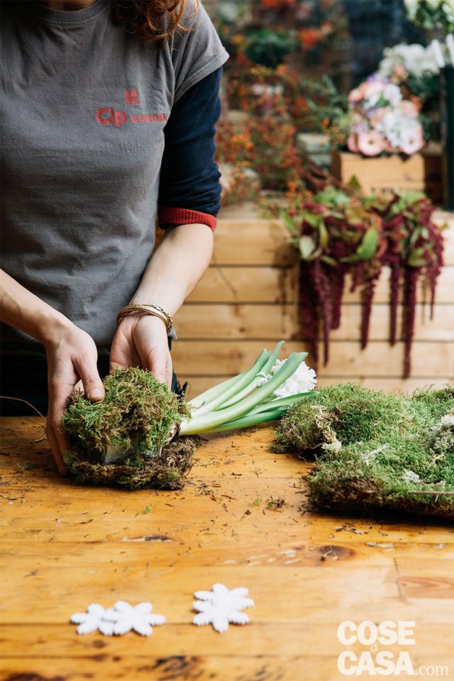 3. Ruotare il contenitore per rivestirlo completamente di muschio. Qualora vi fossero parti scoperte, aggiungere piccoli rattoppi di muschio, che renderanno più irregolare e, quindi, più naturale, la composizione. Durante questa fase vi suggeriamo di lavorare appoggiando il vasetto sul tavolo. 3. Ruotare il contenitore per rivestirlo completamente di muschio. Qualora vi fossero parti scoperte, aggiungere piccoli rattoppi di muschio, che renderanno più irregolare e, quindi, più naturale, la composizione. Durante questa fase vi suggeriamo di lavorare appoggiando il vasetto sul tavolo.