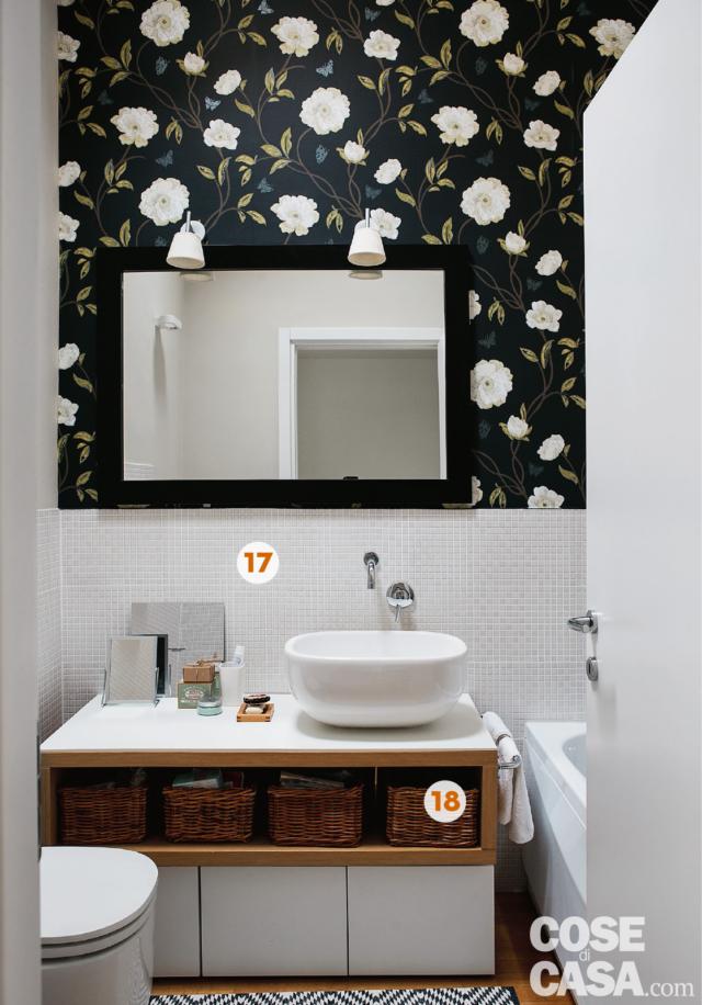 Bagno del mini loft ristrutturato, carata da parati decorativa su fondo scuro e disegni bianchi, lavabo da appoggio, specchio, sanitari e vasca Bagno del mini loft ristrutturato, carata da parati decorativa su fondo scuro e disegni bianchi, lavabo da appoggio, specchio, sanitari e vasca