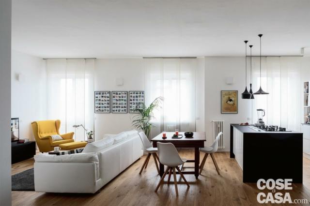 (foto2) Un appartamento di impianto tradizionale, trasformato in un ampio bilocale con zona giorno trattata come un open space, richiede un trattamento delle schermature tessili di taglio moderno e informale. Pratico, poiché la protezione solare delle aperture in serie affacciate a sud-ovest deve essere modulata a seconda dei diversi angoli funzionali dell’ambiente, e nel contempo piacevole. Perfette in tal caso le tende a pannelli scorrevoli montate su binario a soffitto: una scelta che trasforma il fondale delle azioni quotidiane – cucinare, pranzare o studiare/lavorare, conversare e rilassarsi – in una sorta di scena mobile, da calibrare a piacere con semplici movimenti. La quantità corretta di luce viene controllata anche dalla possibilità di sovrapposizione dei pannelli, mentre la verticalità geometrica degli elementi scandisce lo sviluppo spaziale, dando uniformità all’insieme e facendo sembrare più alto il soffitto. (foto2) Un appartamento di impianto tradizionale, trasformato in un ampio bilocale con zona giorno trattata come un open space, richiede un trattamento delle schermature tessili di taglio moderno e informale. Pratico, poiché la protezione solare delle aperture in serie affacciate a sud-ovest deve essere modulata a seconda dei diversi angoli funzionali dell’ambiente, e nel contempo piacevole. Perfette in tal caso le tende a pannelli scorrevoli montate su binario a soffitto: una scelta che trasforma il fondale delle azioni quotidiane – cucinare, pranzare o studiare/lavorare, conversare e rilassarsi – in una sorta di scena mobile, da calibrare a piacere con semplici movimenti. La quantità corretta di luce viene controllata anche dalla possibilità di sovrapposizione dei pannelli, mentre la verticalità geometrica degli elementi scandisce lo sviluppo spaziale, dando uniformità all’insieme e facendo sembrare più alto il soffitto.