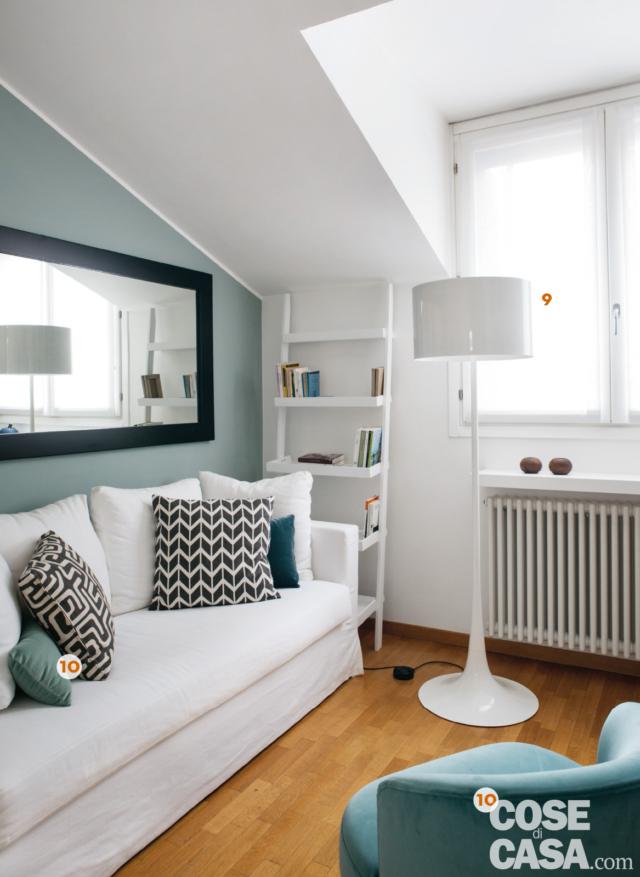 sottotetto del mini loft ristrutturato, parete azzurra, divano, poltroncina, lampada da terra di design, mini libreria sottotetto del mini loft ristrutturato, parete azzurra, divano, poltroncina, lampada da terra di design, mini libreria