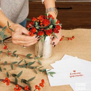 6. Inserire l’Ilex nella composizione, intervallandolo ai fiori e alla foglie. A questo punto prendere il barattolo, allontanarlo da sé e farlo ruotare per verificare che ci sia una buona distribuzione di fiori, bacche e foglie e non ci siano vuoti, e che il peso ottico dei vari elementi sia calibrato. 6. Inserire l’Ilex nella composizione, intervallandolo ai fiori e alla foglie. A questo punto prendere il barattolo, allontanarlo da sé e farlo ruotare per verificare che ci sia una buona distribuzione di fiori, bacche e foglie e non ci siano vuoti, e che il peso ottico dei vari elementi sia calibrato.