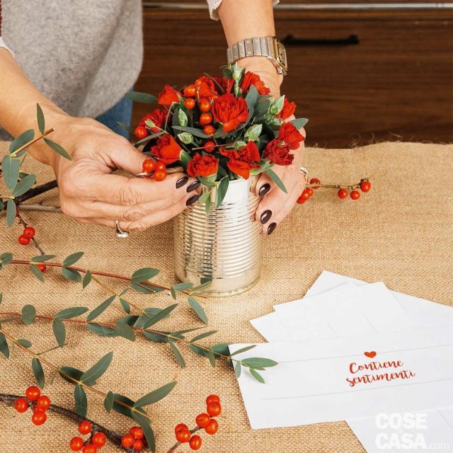 6. Inserire l’Ilex nella composizione, intervallandolo ai fiori e alla foglie. A questo punto prendere il barattolo, allontanarlo da sé e farlo ruotare per verificare che ci sia una buona distribuzione di fiori, bacche e foglie e non ci siano vuoti, e che il peso ottico dei vari elementi sia calibrato. 6. Inserire l’Ilex nella composizione, intervallandolo ai fiori e alla foglie. A questo punto prendere il barattolo, allontanarlo da sé e farlo ruotare per verificare che ci sia una buona distribuzione di fiori, bacche e foglie e non ci siano vuoti, e che il peso ottico dei vari elementi sia calibrato.