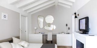 camera sottotetto soffitto legno bianco pareti grigie finto camino