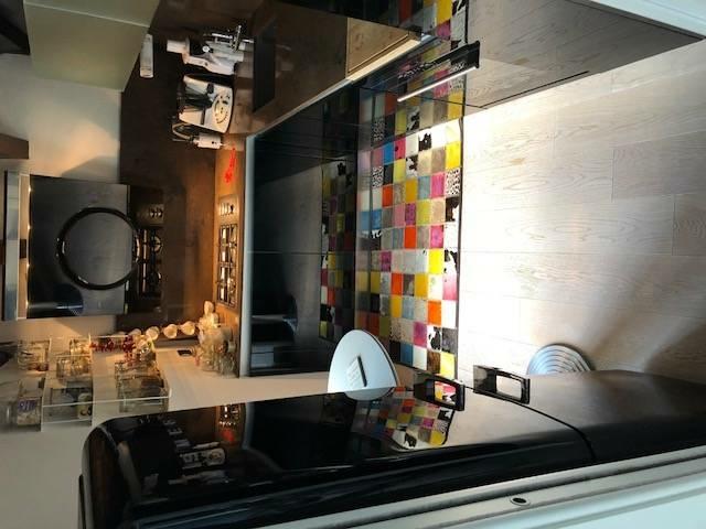 La cucina, separata dal soggiorno da una porta scorrevole, è piccola ma perfettamente organizzata. Uno spazio inaspettatamente carico di cromatismi, rispetto al resto dell’abitazione con tappeto multicolor, mobili laccati nero lucido, top e schienale marrone castagna. Declinata in nero anche la tecnologia, ovvero la cappa Elica e il frigorifero bombato Smeg. La cucina, separata dal soggiorno da una porta scorrevole, è piccola ma perfettamente organizzata. Uno spazio inaspettatamente carico di cromatismi, rispetto al resto dell’abitazione con tappeto multicolor, mobili laccati nero lucido, top e schienale marrone castagna. Declinata in nero anche la tecnologia, ovvero la cappa Elica e il frigorifero bombato Smeg.