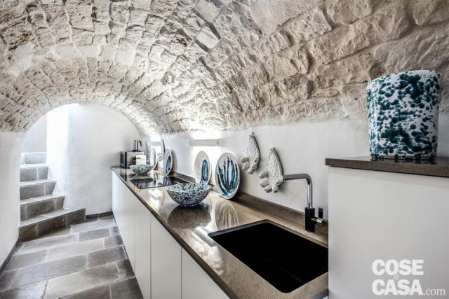 Il secondo ex magazzino preesistente sulla terrazza è stato riconvertito in cucina a servizio dello spazio aperto, per momenti di convivialità più pratici e funzionali, dotata di piccolo bagno di servizio (con lavabo e wc). La composizione in linea Essebi, con basi laccate bianco opaco e top nella stessa nuance della pietra a vista della volta a botte, organizza in poco spazio tutto il necessario. E il minimalismo del disegno viene stemperato dalle ceramiche decorate di CNF Grottaglie, che rileggono la tradizione in chiave contemporanea. Il secondo ex magazzino preesistente sulla terrazza è stato riconvertito in cucina a servizio dello spazio aperto, per momenti di convivialità più pratici e funzionali, dotata di piccolo bagno di servizio (con lavabo e wc). La composizione in linea Essebi, con basi laccate bianco opaco e top nella stessa nuance della pietra a vista della volta a botte, organizza in poco spazio tutto il necessario. E il minimalismo del disegno viene stemperato dalle ceramiche decorate di CNF Grottaglie, che rileggono la tradizione in chiave contemporanea.