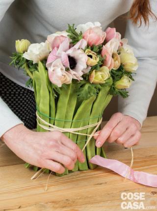 Completare la composizione alternando fiori aperti a fiori chiusi e distribuendo le sfumature e le altezze in modo che la composizione risulti uniforme da tutti
i lati. Infine, legare i fagiolini con un paio di giri di rafia e chiudere con un nodo ben fermo. Eliminare gli elastici. Terminare il lavoro avvolgendo il nastro sopra la rafia, fare un fiocco e dargli “forma” con le mani. Completare la composizione alternando fiori aperti a fiori chiusi e distribuendo le sfumature e le altezze in modo che la composizione risulti uniforme da tutti
i lati. Infine, legare i fagiolini con un paio di giri di rafia e chiudere con un nodo ben fermo. Eliminare gli elastici. Terminare il lavoro avvolgendo il nastro sopra la rafia, fare un fiocco e dargli “forma” con le mani.
