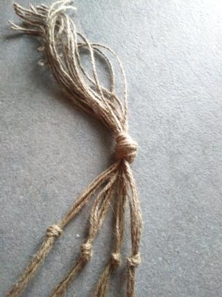 Tagliate 16 pezzi di spago abbastanza spesso, lunghi 150 cm, e annodateli insieme alla base Tagliate 16 pezzi di spago abbastanza spesso, lunghi 150 cm, e annodateli insieme alla base