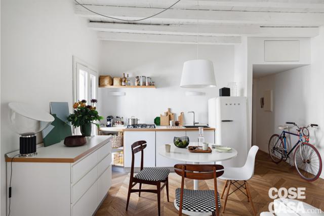 mini bilocale, zona cottura, tavolo da pranzo rotondo, sedie, credenza, lampada a sospensione bianca, pavimento in parquet mini bilocale, zona cottura, tavolo da pranzo rotondo, sedie, credenza, lampada a sospensione bianca, pavimento in parquet