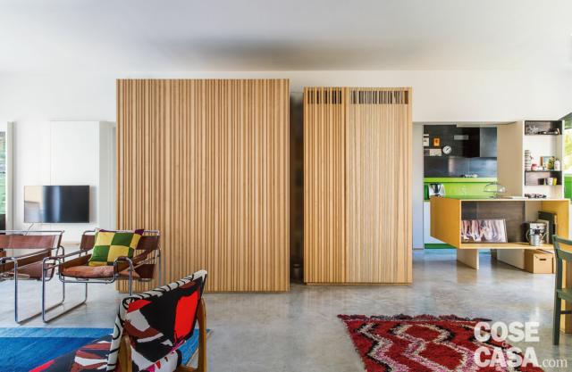 open space, pavimenti in cemento, zona conversazione, area cucina-pranzo, blocco multifunzione con rivestimenti in legno di acero open space, pavimenti in cemento, zona conversazione, area cucina-pranzo, blocco multifunzione con rivestimenti in legno di acero