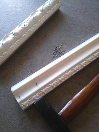 Girate le cornici e fissate dei chiodini a distanze regolari, lasciandoli abbastanza sporgenti Girate le cornici e fissate dei chiodini a distanze regolari, lasciandoli abbastanza sporgenti