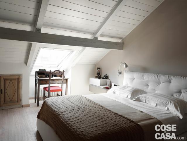 recupero del sottotetto, camera matrimoniale, letto con testiera capitonné rivestita in tessuto bianco, lucernario, pavimento in parquet, applique per la zona lettura recupero del sottotetto, camera matrimoniale, letto con testiera capitonné rivestita in tessuto bianco, lucernario, pavimento in parquet, applique per la zona lettura