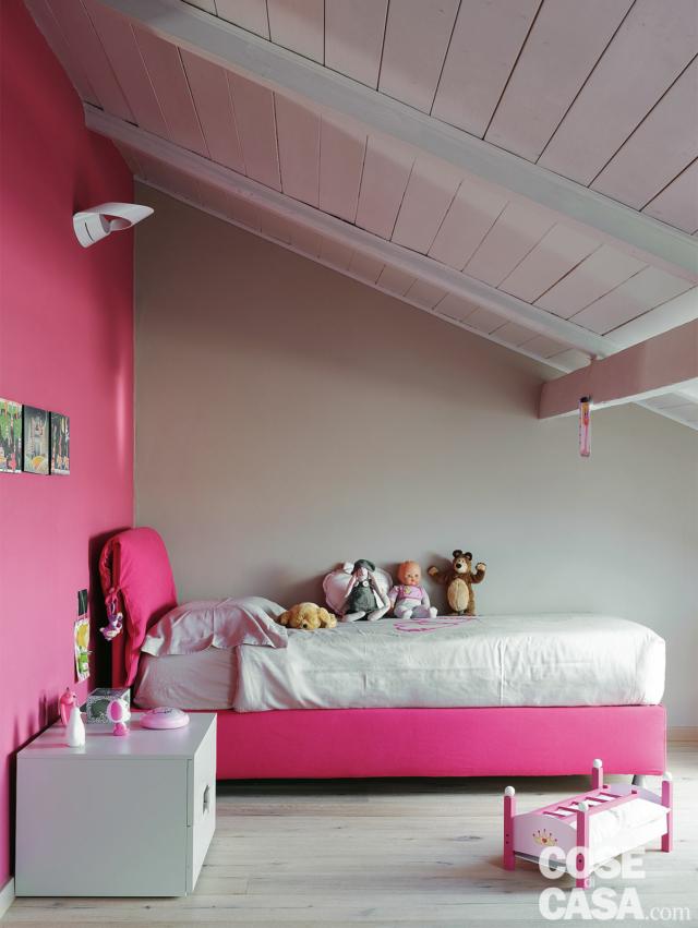 recupero del sottotetto, camera ragazzi, letto singolo tessile, comodino, parete e tessuti in finitura fucsia, tetto inclinato, travi e assito in legno recupero del sottotetto, camera ragazzi, letto singolo tessile, comodino, parete e tessuti in finitura fucsia, tetto inclinato, travi e assito in legno