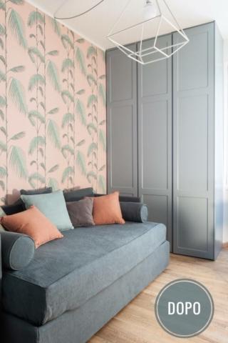 camera degli ospiti con divano letto grigio, cuscini colorati, carta da parati rosa con foglie verdi