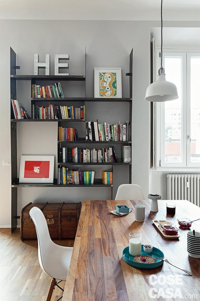 zona pranzo nell'abitazione da single, tavolo con piano in legno, sedie di design, lampada a sospensione, libreria a giorno zona pranzo nell'abitazione da single, tavolo con piano in legno, sedie di design, lampada a sospensione, libreria a giorno