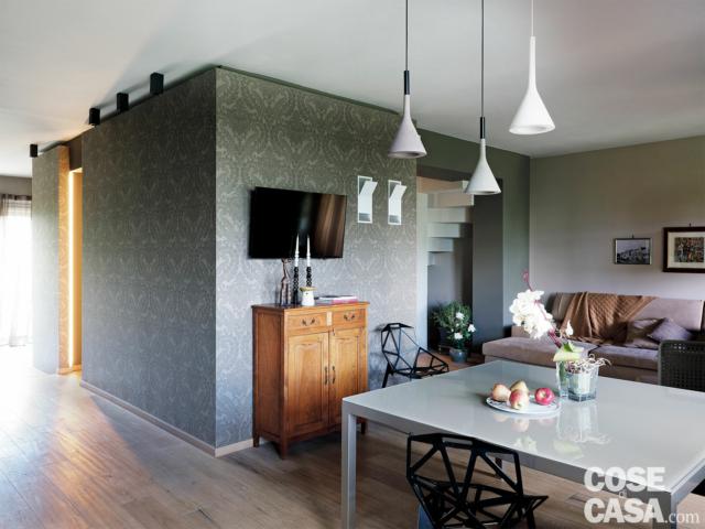 zona pranzo, lampade a sospensione, credenza in legno, blocco multifunzione rivestito con carta da parati grigia, vano scala mimetizzato zona pranzo, lampade a sospensione, credenza in legno, blocco multifunzione rivestito con carta da parati grigia, vano scala mimetizzato