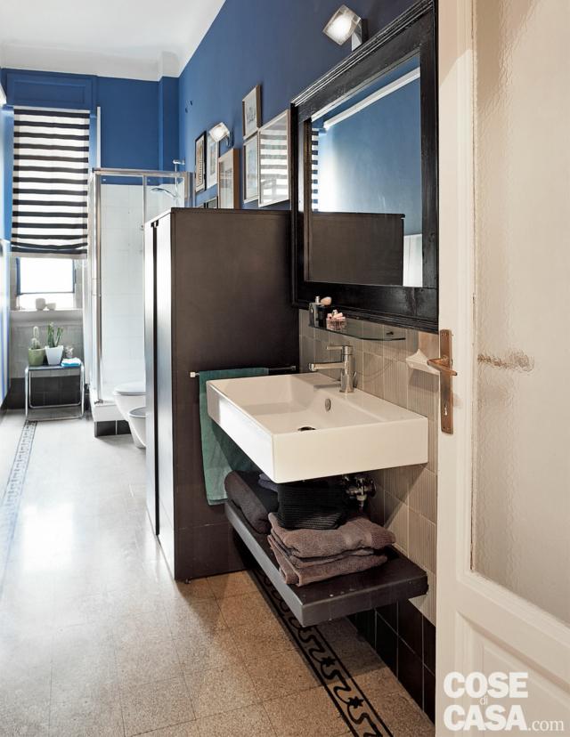 bilocale tradizionale, bagno lungo e stretto, pavimento in cementine, lavabo e ripiano sospesi, pareti blu, armadio, box doccia, finestra bilocale tradizionale, bagno lungo e stretto, pavimento in cementine, lavabo e ripiano sospesi, pareti blu, armadio, box doccia, finestra