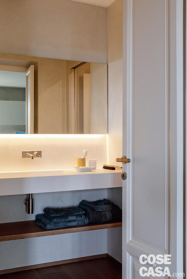 bagno, porta, piano sospeso rivestito in resina, rubinetto a placca, specchio, illuminazione sottopensile, ripiano basso in legno bagno, porta, piano sospeso rivestito in resina, rubinetto a placca, specchio, illuminazione sottopensile, ripiano basso in legno