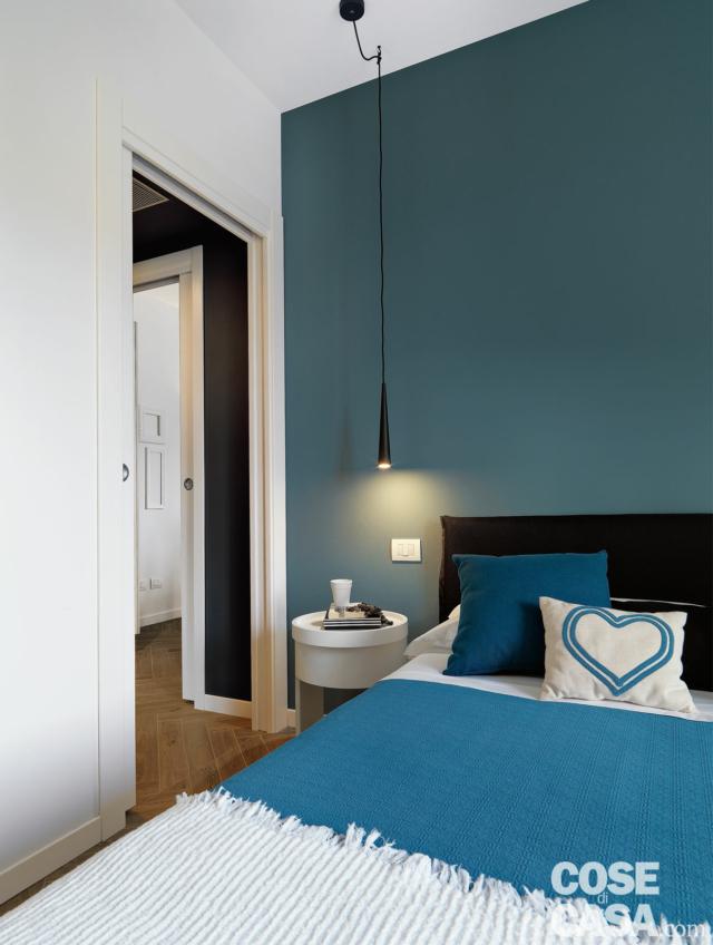 camera matrimoniale, parete blu, letto tessile, comodino bianco tondo, lampada a sospensione, cuscino camera matrimoniale, parete blu, letto tessile, comodino bianco tondo, lampada a sospensione, cuscino