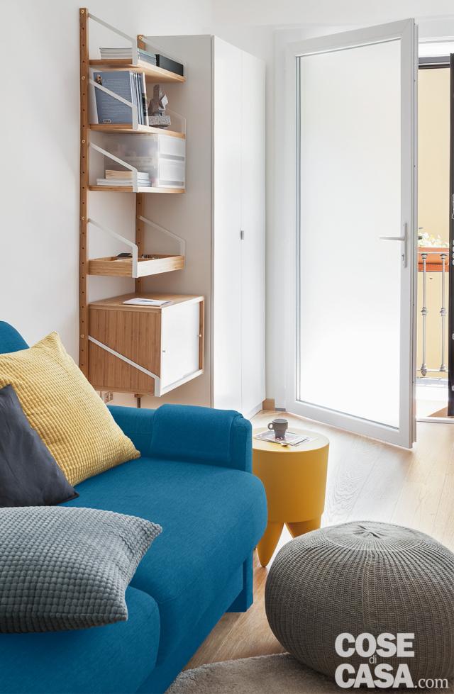 bilocale mini, ingresso, porta vetrata, armadio, libreria in legno, divano azzurro, pouf, tavolino giallo bilocale mini, ingresso, porta vetrata, armadio, libreria in legno, divano azzurro, pouf, tavolino giallo