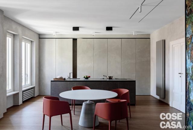 zona pranzo, tavolo rotondo, poltroncine rosse, isola attrezzata, cucina chiusa da ante scorrevoli, finestre, faretti, parquet zona pranzo, tavolo rotondo, poltroncine rosse, isola attrezzata, cucina chiusa da ante scorrevoli, finestre, faretti, parquet