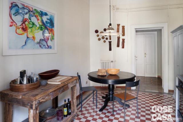 cucina, tavolo da pranzo rotondo in legno, tavolo da lavoro in legno grezzo, lampada a sospensione, pavimento in cementine, radiatore in ghisa, quadro cucina, tavolo da pranzo rotondo in legno, tavolo da lavoro in legno grezzo, lampada a sospensione, pavimento in cementine, radiatore in ghisa, quadro