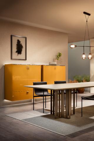 (LT40 lema composizione gialla + LT40 lema dettaglio top marmo) Sistema articolato ed altamente personalizzabile, nelle composizioni e nelle finiture, LT40 (design David Lopez Quincoces) di Lema si mette al servizio di ogni ambiente domestico con eleganza e discrezione. I contenitori pensili, chiusi da ante e da cassetti, ben si prestano così a celare accessori, utensili e tessuti per la tavola, diventando con l’originale finitura laccata giallo senape elementi caratterizzanti dello spazio. L’illuminazione a led integrata stacca i volumi dalla parete retrostante, alleggerendone la presenza e sottolineando la cura dei dettagli: come il top di marmo scuro a contrasto dall’esile spessore, contenuto dai fianchi di finitura per un effetto estremamente moderno, o le maniglie di legno e metallo, disegnate come architetture a scala ridottissima.