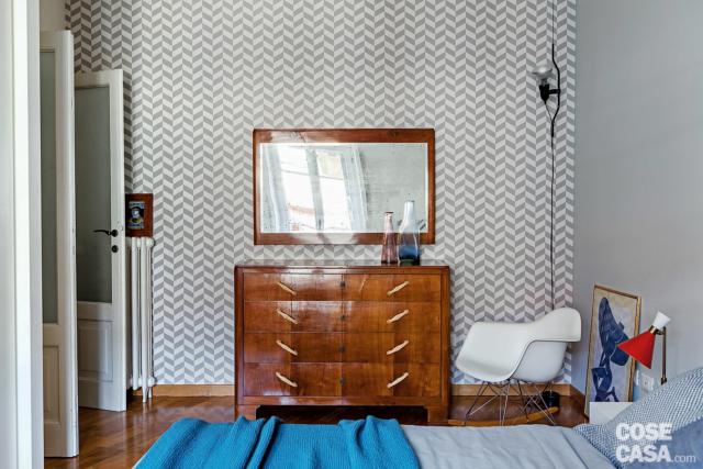 camera matrimoniale, cassettiera anni '50 con specchio, lampada a sospensione Parentesi, carta da parati con motivo geometrico, poltroncine basculante di design, porta in legno e vetro a doppio battente, letto camera matrimoniale, cassettiera anni '50 con specchio, lampada a sospensione Parentesi, carta da parati con motivo geometrico, poltroncine basculante di design, porta in legno e vetro a doppio battente, letto