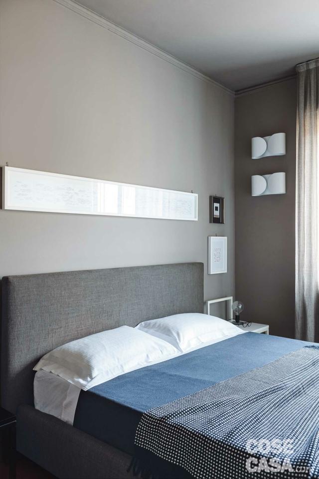 bilocale, camera matrimoniale, letto tessile, stampa incorniciata, applique di design, pareti grigie, finestra bilocale, camera matrimoniale, letto tessile, stampa incorniciata, applique di design, pareti grigie, finestra