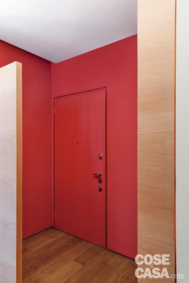 spazi irregolari, ingresso, porta, pareti rosse, quinta divisoria, pavimento in parquet spazi irregolari, ingresso, porta, pareti rosse, quinta divisoria, pavimento in parquet