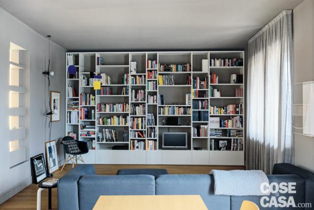 soggiorno, finestre, libreria a tutt'altezza, lampada Parentesi, nicchia passante, divano azzurro, pavimento in parquet soggiorno, finestre, libreria a tutt'altezza, lampada Parentesi, nicchia passante, divano azzurro, pavimento in parquet