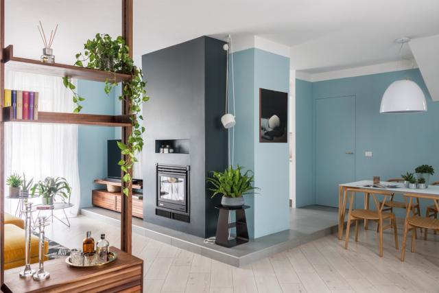 living, blocco centrale con camino e zona tv, pedana, tavolo da pranzo, lampada a sospensione, libreria passante, pareti azzurre living, blocco centrale con camino e zona tv, pedana, tavolo da pranzo, lampada a sospensione, libreria passante, pareti azzurre