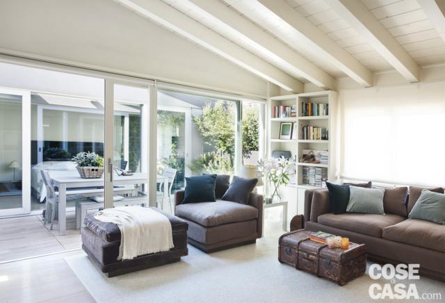 mansarda ristrutturata, soggiorno, divano, poltrona, pouf rivestiti in tessuto grigio, soffitto in legno laccato bianco con travi a vista, vetrate, terrazzino, tavolo da pranzo mansarda ristrutturata, soggiorno, divano, poltrona, pouf rivestiti in tessuto grigio, soffitto in legno laccato bianco con travi a vista, vetrate, terrazzino, tavolo da pranzo