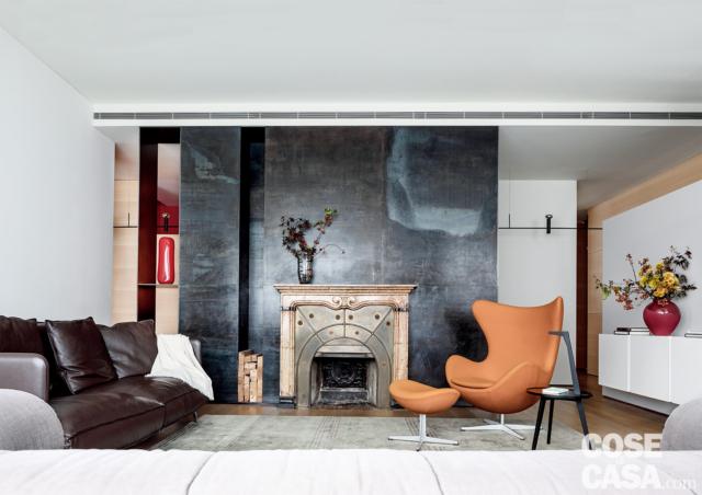 soggiorno, camino, divisorio in lamiera, poltrona di design arancione con poggiapiedi, mobile sospeso in laccato bianco, divano in pelle, controsoffitto soggiorno, camino, divisorio in lamiera, poltrona di design arancione con poggiapiedi, mobile sospeso in laccato bianco, divano in pelle, controsoffitto