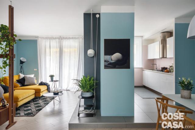 sottotetto in stile nordico, zona conversazione, divano color senape, tappeto bianco e nero, pareti azzurre, muro divisorio, pedana, cucina, lampade di design sottotetto in stile nordico, zona conversazione, divano color senape, tappeto bianco e nero, pareti azzurre, muro divisorio, pedana, cucina, lampade di design