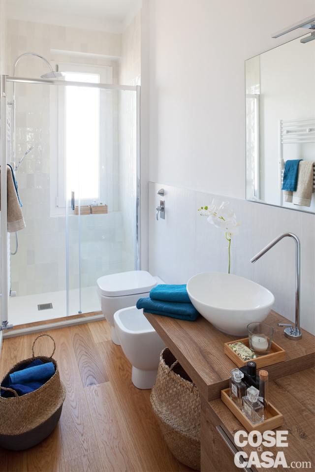 bagno del monolocale, piano sospeso in legno, lavabo da appoggio, rubinetto a colonna, sanitari, specchio, box doccia con apertura scorrevole, finestra bagno del monolocale, piano sospeso in legno, lavabo da appoggio, rubinetto a colonna, sanitari, specchio, box doccia con apertura scorrevole, finestra