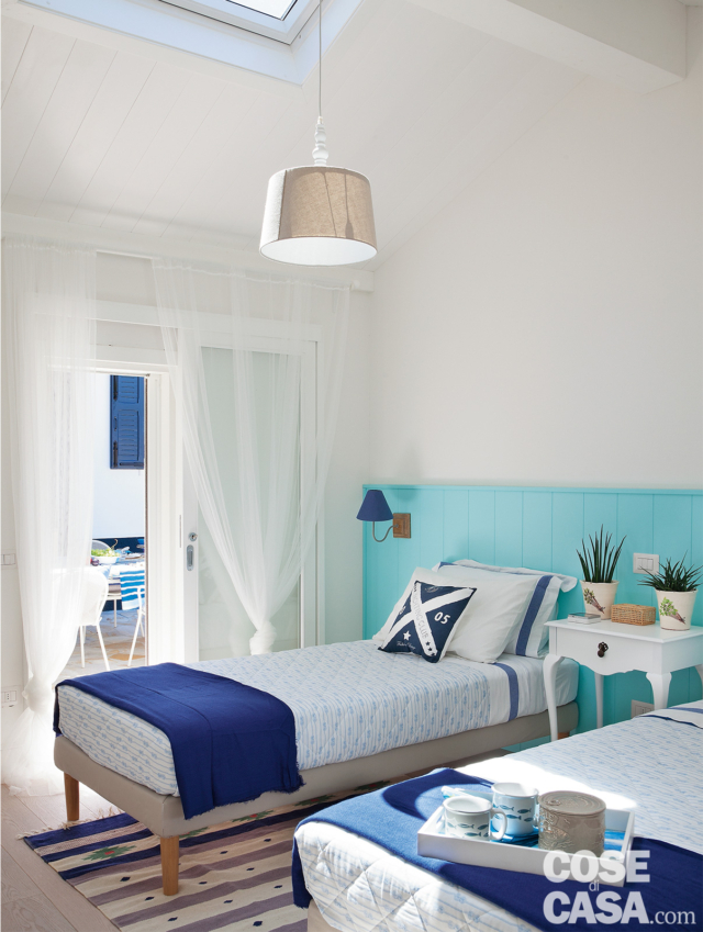 camera a due letti, lucernario, lampada a sospensione, letti singoli, boiserie azzurra, plaid blu, tappeto a righe camera a due letti, lucernario, lampada a sospensione, letti singoli, boiserie azzurra, plaid blu, tappeto a righe