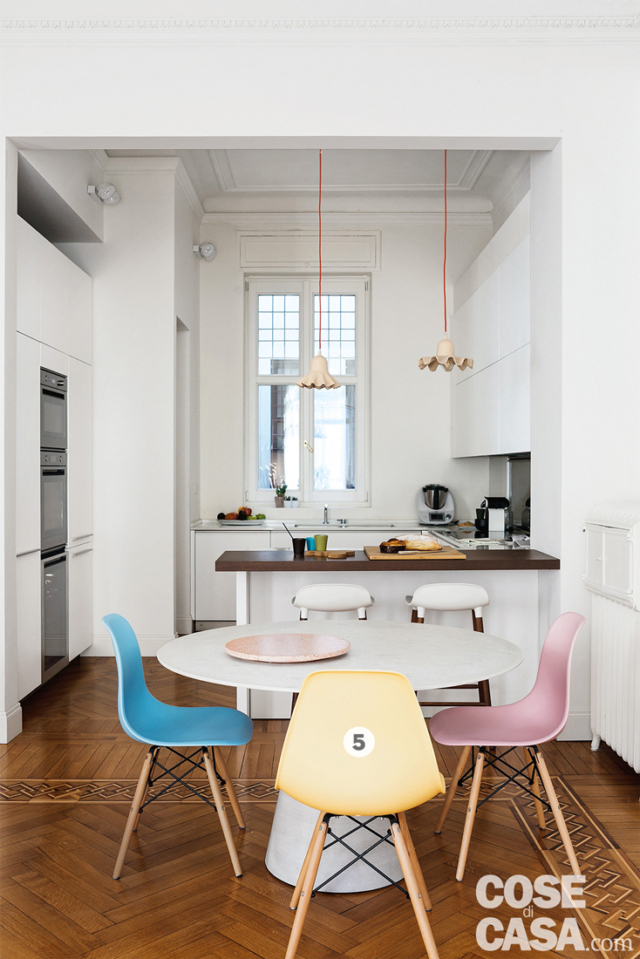 zona cottura, tavolo, sedie di design colorate, bancone snack, lampade a sospensione sagomate, colonna forno, parquet, intarsi zona cottura, tavolo, sedie di design colorate, bancone snack, lampade a sospensione sagomate, colonna forno, parquet, intarsi