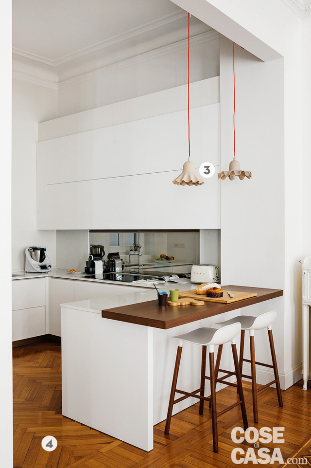 cucina a vista della casa d'epoca, bancone snack in legno di rovere, sgabelli, lampade a sospensione sagomate, zona cottura in laccato bianco, parquet a spina di pesce cucina a vista della casa d'epoca, bancone snack in legno di rovere, sgabelli, lampade a sospensione sagomate, zona cottura in laccato bianco, parquet a spina di pesce