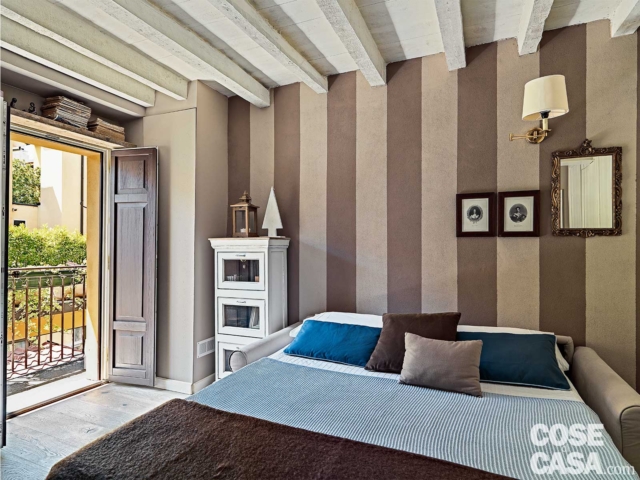 monolocale, ballatoio, ingresso, parete a strisce verticali, divano trasformato in letto, applique, travi a vista, pavimento in legno, monolocale, ballatoio, ingresso, parete a strisce verticali, divano trasformato in letto, applique, travi a vista, pavimento in legno,