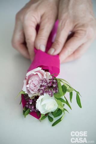 6. Ricavare 6 quadrati 20 x 20 cm di carta velina. Avvolgere ognuno a formare un cono con un lembo più alto. Inserire il bouquet nel cono di carta, adagiando
i fiori sopra il lembo più alto e facendoli scivolare verso il basso, in modo che la carta contenga le corolle. Tenere premuta la parte centrale del cono con delicatezza per farla aderire agli steli.