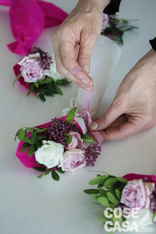 8. Chiudere il bouquet con il nastrino bianco e fucsia facendo un semplice nodo doppio. I mini bouquet possono essere conservati
in frigorifero fino al momento di essere disposti sulla tavola, accanto al piatto oppure, come in foto, a formare un grazioso centrotavola.