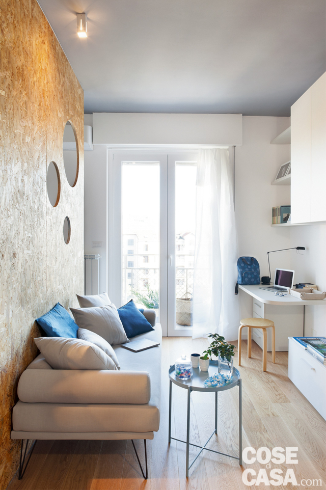 zona conversazione, pannello in OSB, divano con cuscini, faretto, portafinestra, postazione studio con scrivania, armadiatura in laccato bianco opaco, pavimento in parquet zona conversazione, pannello in OSB, divano con cuscini, faretto, portafinestra, postazione studio con scrivania, armadiatura in laccato bianco opaco, pavimento in parquet