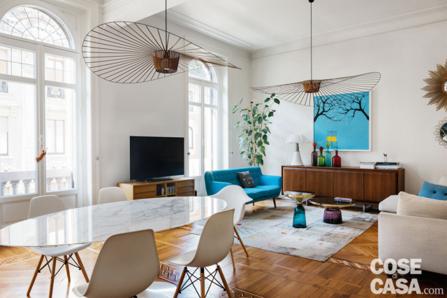 zona giorno open space della casa d'epoca, tavolo ovale e sedie di design, lampadari a ventola, pavimento in parquet, living, portafinestre ad arco zona giorno open space della casa d'epoca, tavolo ovale e sedie di design, lampadari a ventola, pavimento in parquet, living, portafinestre ad arco