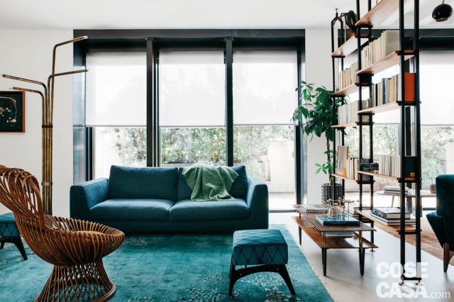 soggiorno, vetrata con tende a rullo, mobile divisorio passante, divano rivestito in tessuto color ottanio, pouf, tapeto, lampada d aterra, poltroncina in vimini, tavolino soggiorno, vetrata con tende a rullo, mobile divisorio passante, divano rivestito in tessuto color ottanio, pouf, tapeto, lampada d aterra, poltroncina in vimini, tavolino