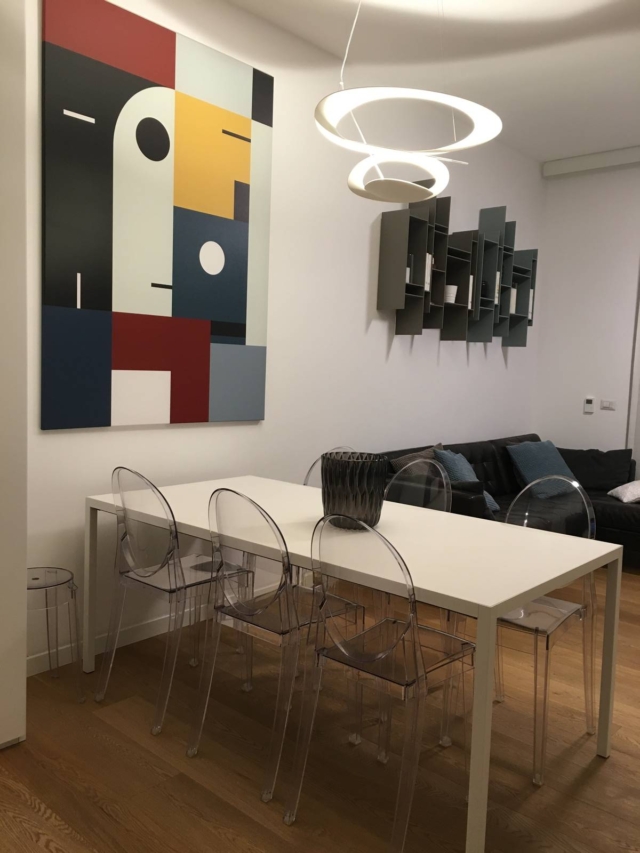soggiorno ravvivato con una grande tela di Posterlounge con due librerie Randomito colorate di MDF, appese sopra il divano con cuscini Ikea che riprendono cromie grigio azzurro. sospensione bianca Pirce di Artemide soggiorno ravvivato con una grande tela di Posterlounge con due librerie Randomito colorate di MDF, appese sopra il divano con cuscini Ikea che riprendono cromie grigio azzurro. sospensione bianca Pirce di Artemide