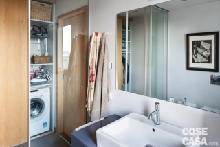 bagno del mini appartamento, specchio, lavabo, porta, zona lavanderia con lavatrice e armadio bagno del mini appartamento, specchio, lavabo, porta, zona lavanderia con lavatrice e armadio